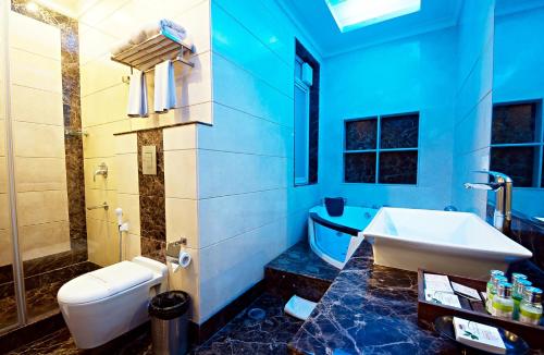 a bathroom with a sink and a toilet and a tub at The Grand Vikalp By Saga Hotels in New Delhi