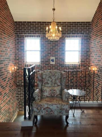 a chair in a room with a brick wall at 墾丁勿忘我城堡莊園 in Hengchun