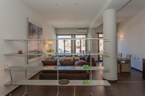 sala de estar con estanterías de cristal y sofá en Faro Apartments en La Canea
