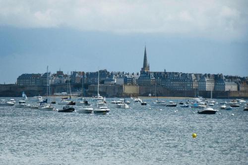 a bunch of boats in the water with a city at Charming Home near Mont St Michel Bay in Cherrueix
