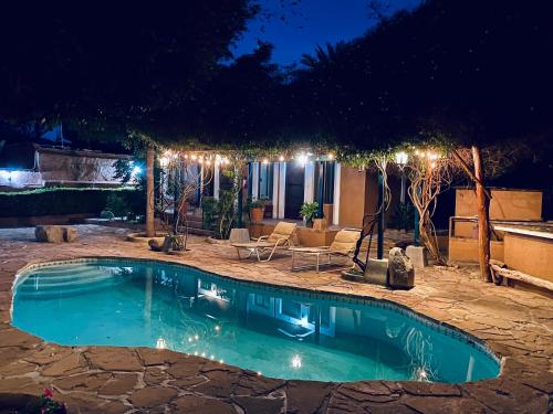 a swimming pool in a yard at night at Hotel Casa María Félix in Álamos