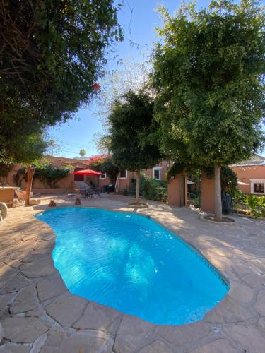 a blue swimming pool with trees in a yard at Hotel Casa María Félix in Álamos