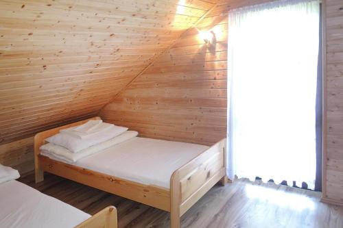 a bed in a room with a wooden wall at Holiday resort, Rewal in Rewal