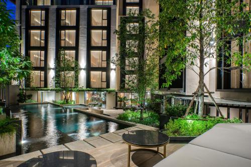a courtyard with a pool in a building at Gardina Asoke Hotel & Residence in Bangkok