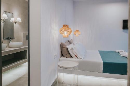 a bedroom with a bed and a table and a sink at Zante Fiore Suites in Xirokástellon