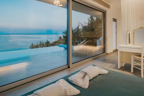 a room with a large window with a view of the ocean at Zante Fiore Suites in Xirokástellon