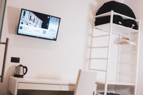 a room with a desk and a tv on the wall at RESIDENZE CASSOLI - Lamezia Centro in Lamezia Terme
