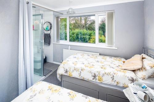 a bedroom with two beds and a window at Steve's Place in Stoney Stanton