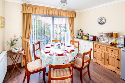 a kitchen with a table with chairs and a table and a window at Steve's Place in Stoney Stanton