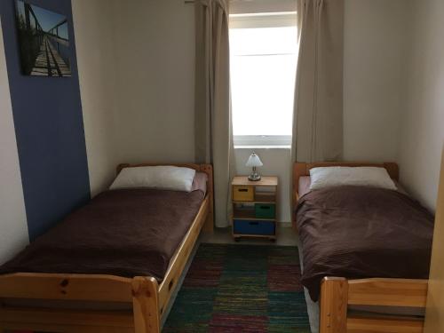 two beds in a small room with a window at Ferienhaus Pirol am Vilzsee in Mirow in Mirow