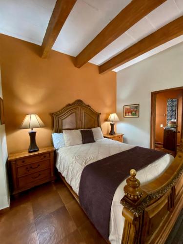 a bedroom with a large bed with two lamps on tables at Hotel Casa María Félix in Álamos