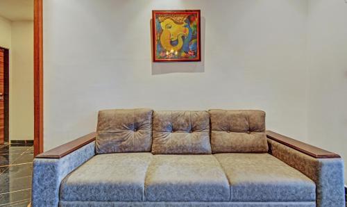 a couch in a living room with a picture on the wall at Tripli Hotels Le Shelton in Udaipur