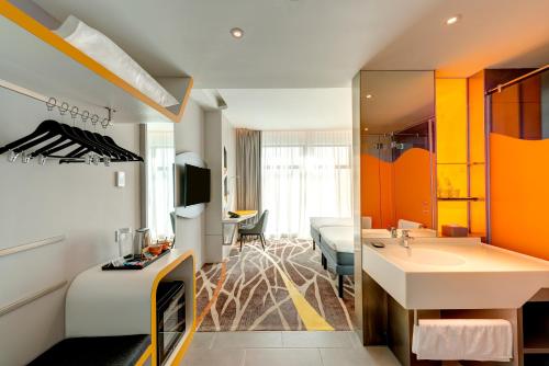 a hotel room with a sink and a bedroom at ibis Styles Johor Iskandar Puteri in Johor Bahru