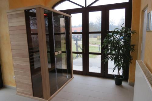 a glass revolving door in a building with a potted plant at Sarlóspuszta Club Hotel in Tatárszentgyörgy