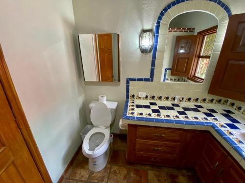 a bathroom with a toilet and a sink and a mirror at Hotel Casa María Félix in Álamos