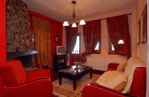 a living room with red furniture and a fireplace at Diaselon in Elatochori