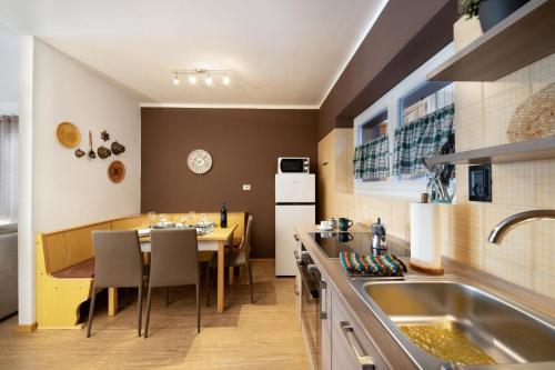 a kitchen with a table and a dining room at Ciasa Piaz de Pavarin in Pera