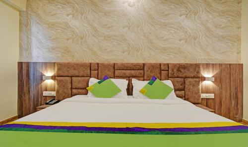 a bedroom with a bed with white sheets and pillows at Tripli Hotels Le Shelton in Udaipur