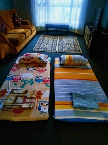a bedroom with a bed and a couch at CosY Klebang Homestay in Kampong Lereh