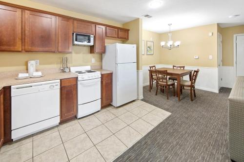a kitchen with white appliances and a table with chairs at Holiday Inn Club Vacations Hill Country Resort at Canyon Lake in Canyon Lake