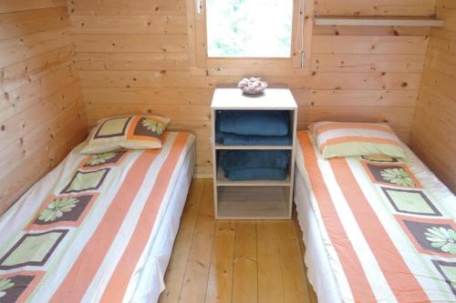 two beds in a log cabin with a desk at Bungalow, Wrzosowo in Wrzosowo