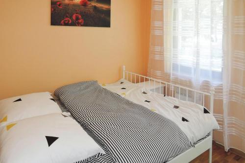 a bedroom with a bed and a window with curtains at Holiday flat, Lukecin in Łukęcin