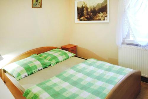 a bedroom with a bed with a green and white checkered sheets at holiday home, Kolczewo in Kołczewo