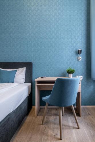 a bedroom with a bed and a desk with a chair at Full Moon Budapest in Budapest