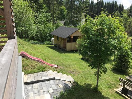a small cabin with a red slide in a yard at Almhaus Teichalm/Sommeralm in Breitenau
