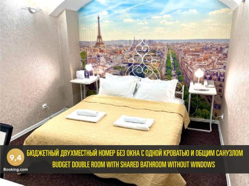 a poster of a bedroom with a view of the eiffel tower at LES Mini Hotel in Almaty