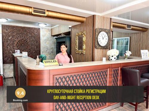 a woman standing behind a bar in a restaurant at LES Mini Hotel in Almaty