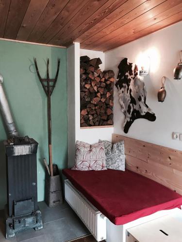 a room with a bench with a fireplace and a cow on the wall at Almhaus Teichalm/Sommeralm in Breitenau