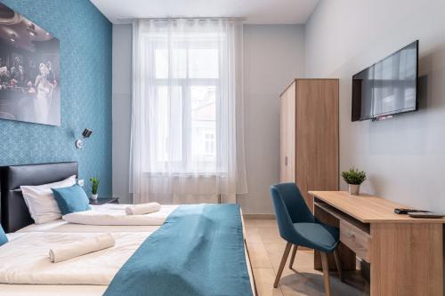 a bedroom with two beds and a desk and a television at Full Moon Budapest in Budapest