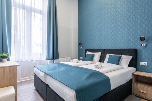a bedroom with a large bed with blue walls at Full Moon Budapest in Budapest