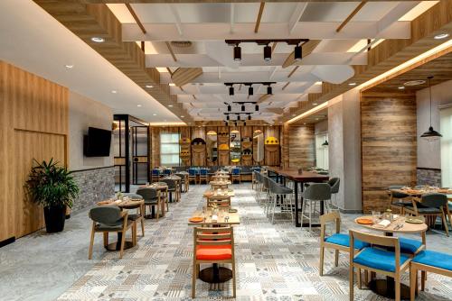 a restaurant with tables and chairs and a bar at ibis Styles Johor Iskandar Puteri in Johor Bahru