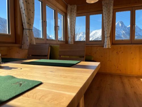 a room with a table and windows and mountains at Ferienwohnungen Kalss nahe Altaussee in Bad Aussee