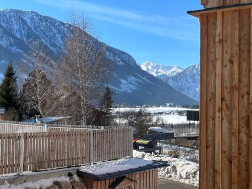 a wooden bench on a deck with mountains in the background at Ferienwohnungen Kalss nahe Altaussee in Bad Aussee