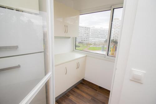 uma cozinha com armários brancos e uma janela em Spacieux T4 Idéal Groupes em Créteil