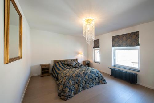 a bedroom with a bed and a chandelier at Residentie Nevejan in Kortrijk