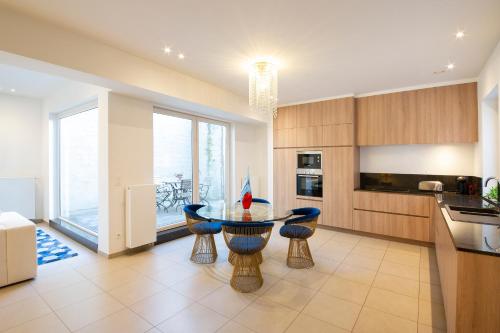 a kitchen with a glass table and some chairs at Residentie Nevejan in Kortrijk