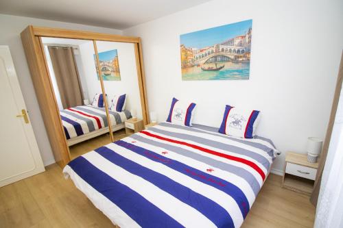 um quarto com uma cama com riscas azuis e brancas em Spacieux T4 Idéal Groupes em Créteil