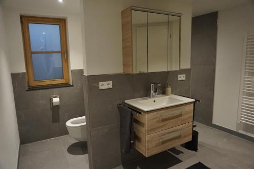 a bathroom with a sink and a toilet at Ferienwohnung Helchenberg in Bad Hindelang