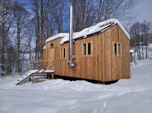 Cabaña de madera con nieve en el techo en la nieve en Celoroční GLAMPING v pohodlném domečku, en Výprachtice