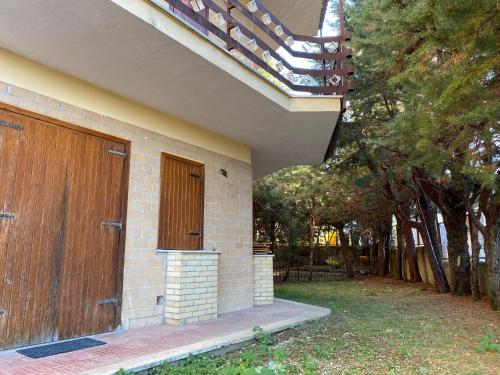 羅卡迪梅佐的住宿－Appartamento con Giardino - Rocca di Mezzo，砖砌的建筑,有木门和树木