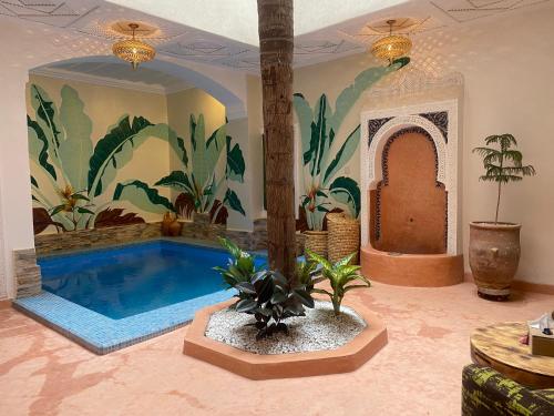a swimming pool in a room with a mural at Riad Celia in Marrakech