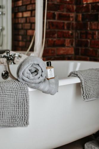 a bath tub with a towel on the side of it at MFT GUEST HOUSE in Boksburg