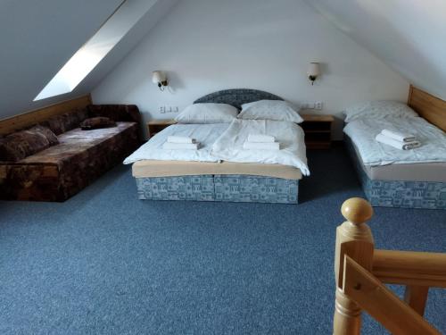 a bedroom with two beds and a couch at Penzion Klášterský mlýn in RejÅ¡tejn