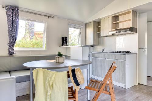 a kitchen and dining room with a table and chairs at Camping maeva Club Argelès Vacances in Argelès-sur-Mer