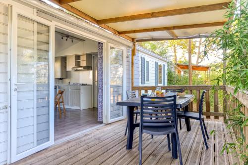 a patio with a table and chairs on a deck at Camping maeva Club Argelès Vacances in Argelès-sur-Mer