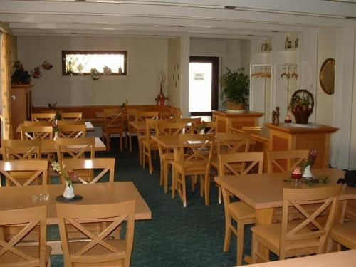 a dining room with wooden tables and chairs at Hotel Koch Maingau in Obertshausen
